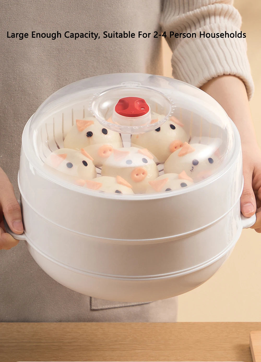 White steamer basket with cartoonish animal designs held by a person, suitable for 2-4 people.