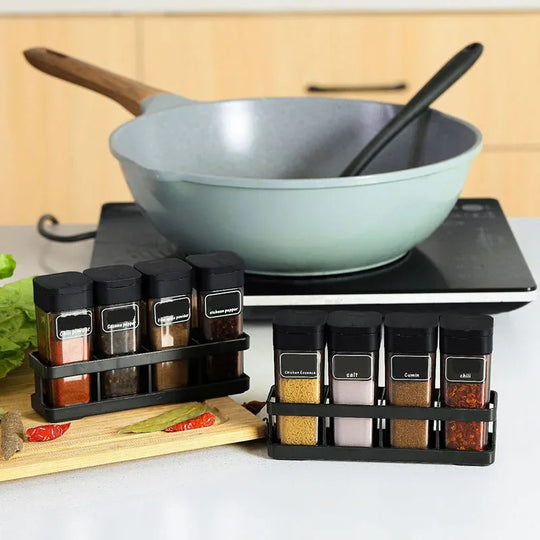 Spice containers on a kitchen counter with a wok in the background