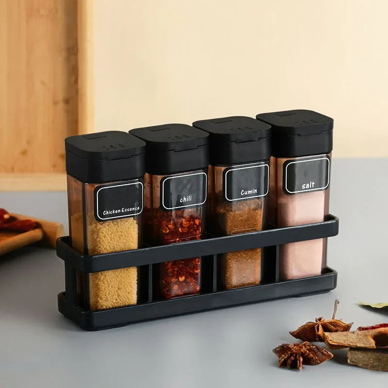 Set of spice jars with black lids on a kitchen counter