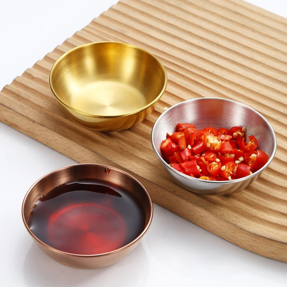 Three bowls containing different ingredients on a wooden board.