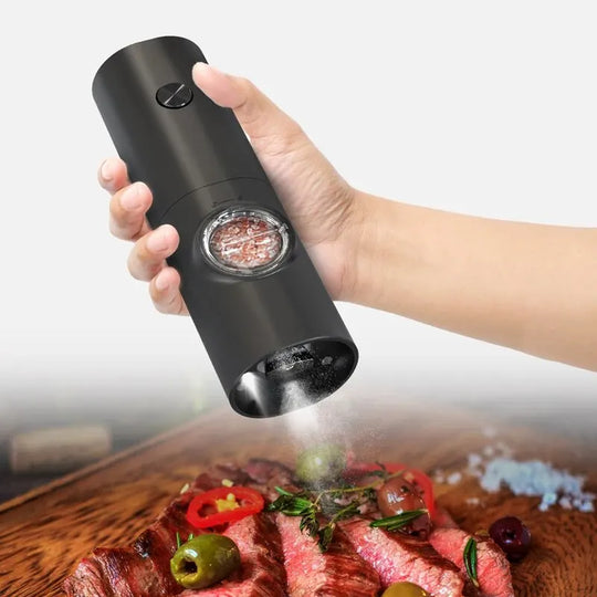 Black pepper grinder being used on a plate of food