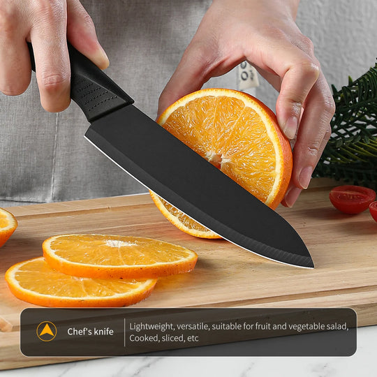 Person slicing an orange with a chef's knife on a wooden cutting board.
