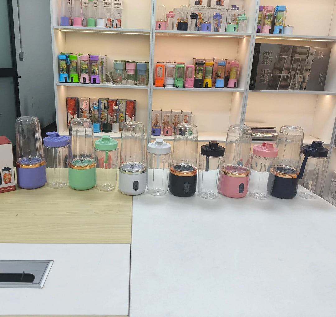 Collection of small portable blenders on a counter with shelves in the background.