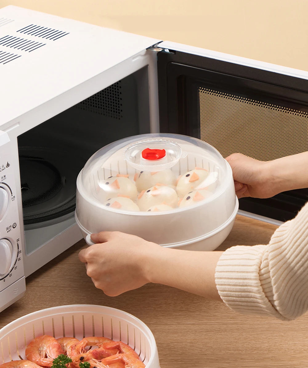 Person using a microwave steamer with food inside on a wooden surface.