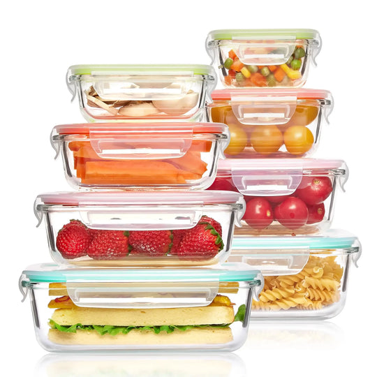 Set of glass food storage containers with colorful lids filled with various foods on a white background