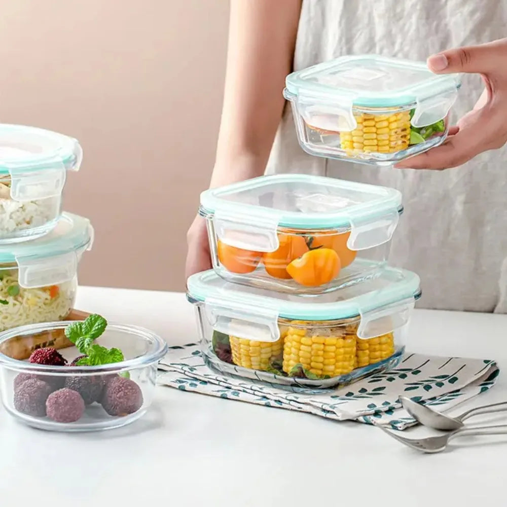 Glass food storage containers with silicone lids on a table.