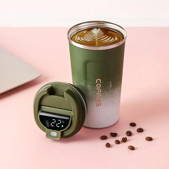Green insulated coffee tumbler with digital temperature display on a pink background